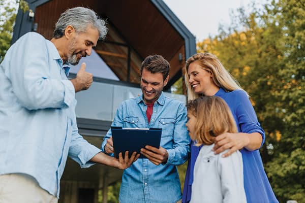 A dealer reviewing coverage with homeowners outside their home